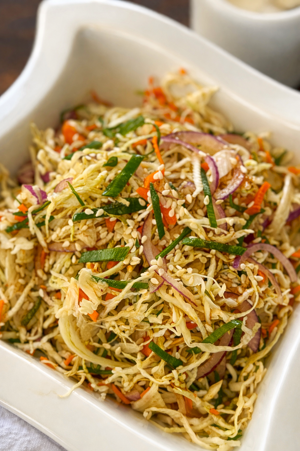 Crunchy Asian cabbage slaw with carrots, red onion, green onions, and sesame seeds.