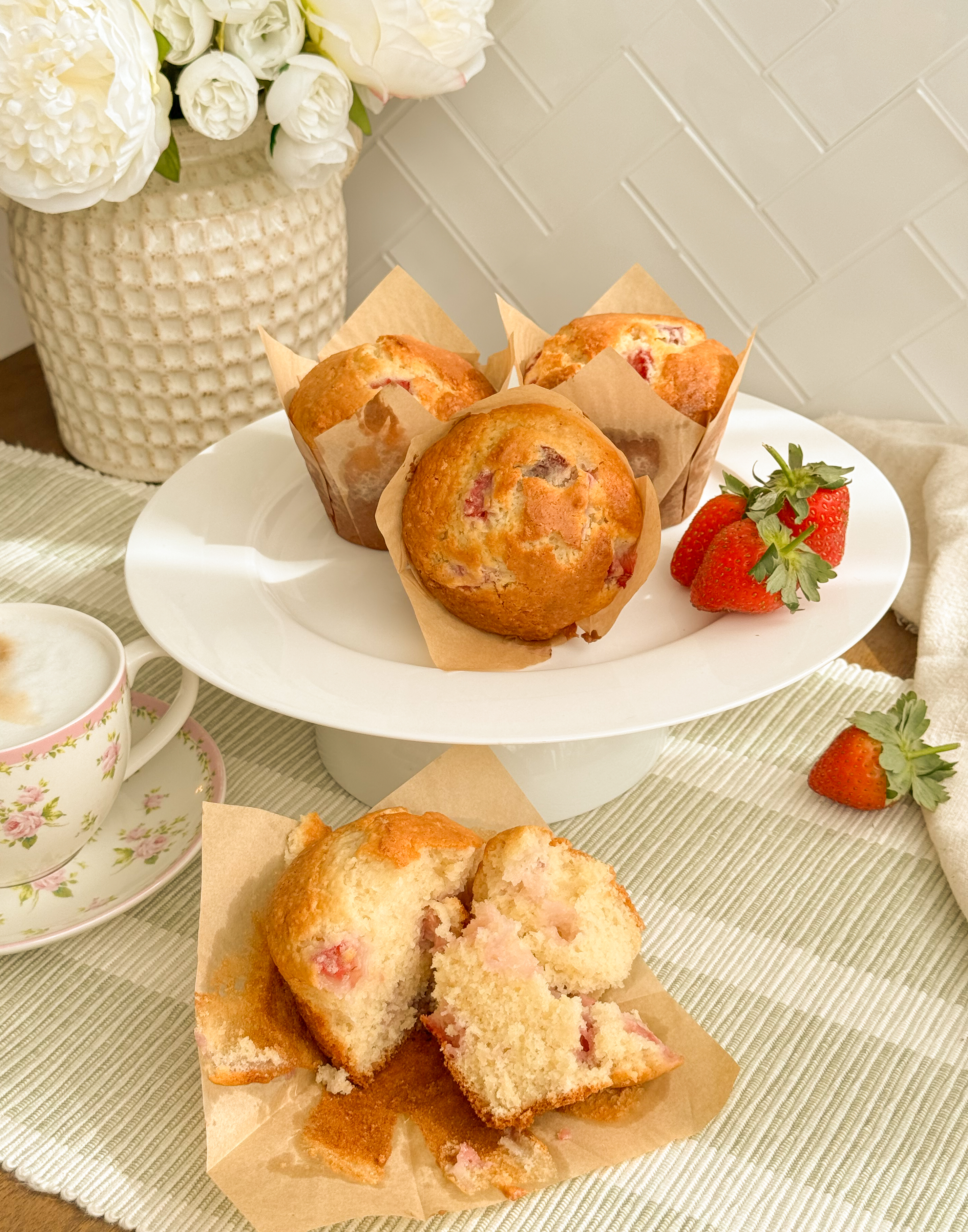 Strawberry and coconut muffins with golden tops and pieces of fresh strawberry.