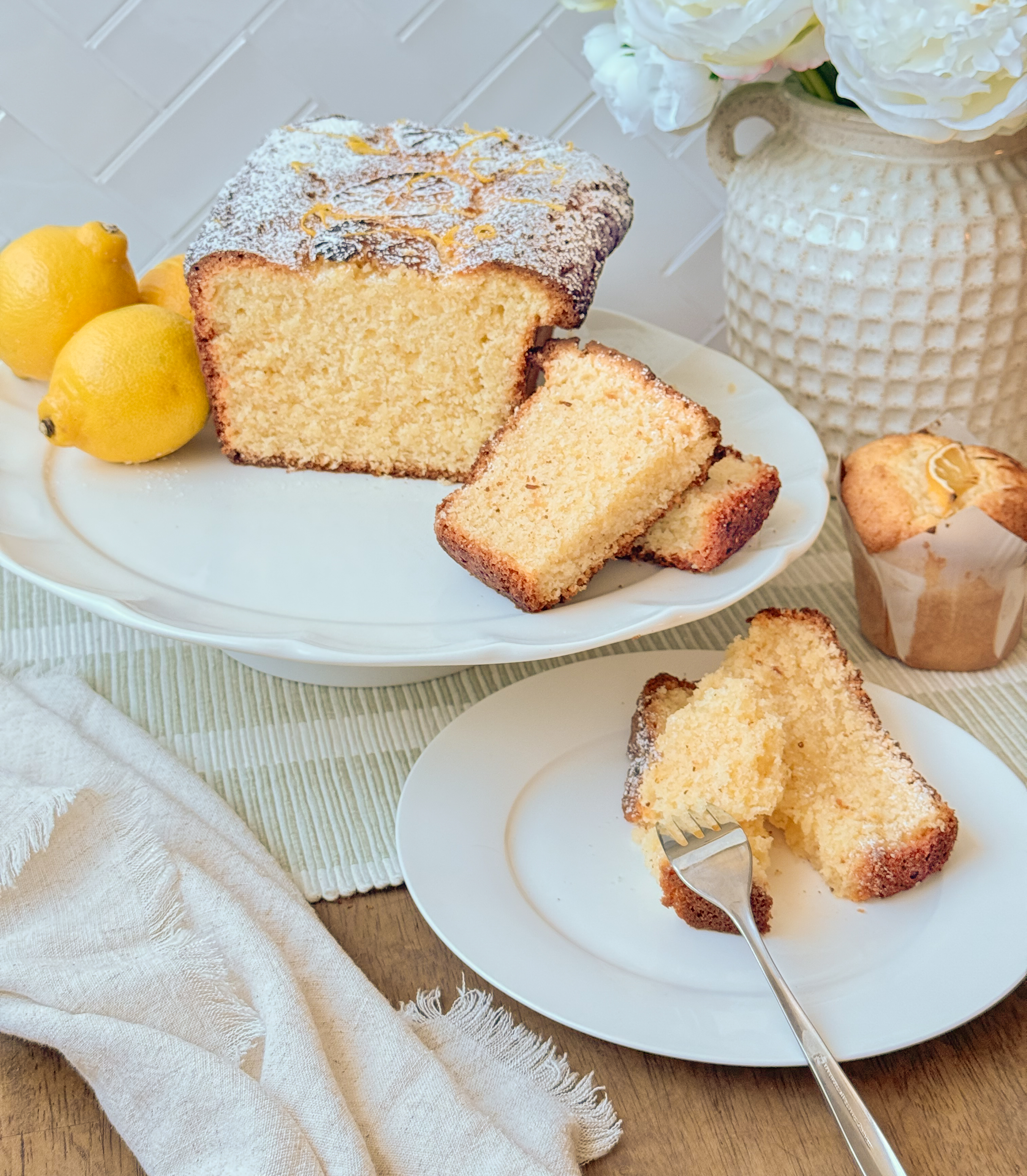 A lemon coconut loaf cake with a white lemon glaze, sliced to show the crumb.