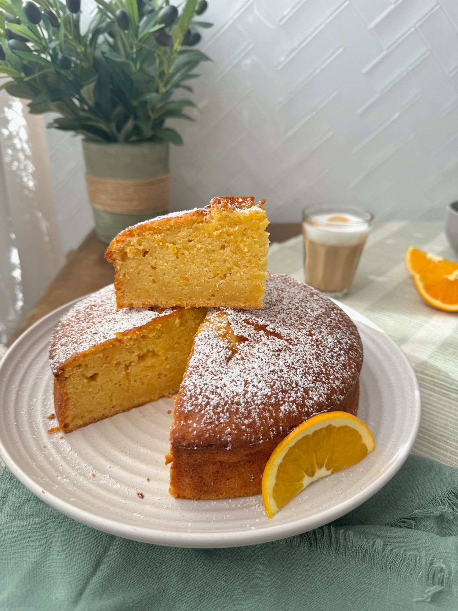 A whole orange olive oil cake with a golden crust and flecks of orange peel in the crumb.