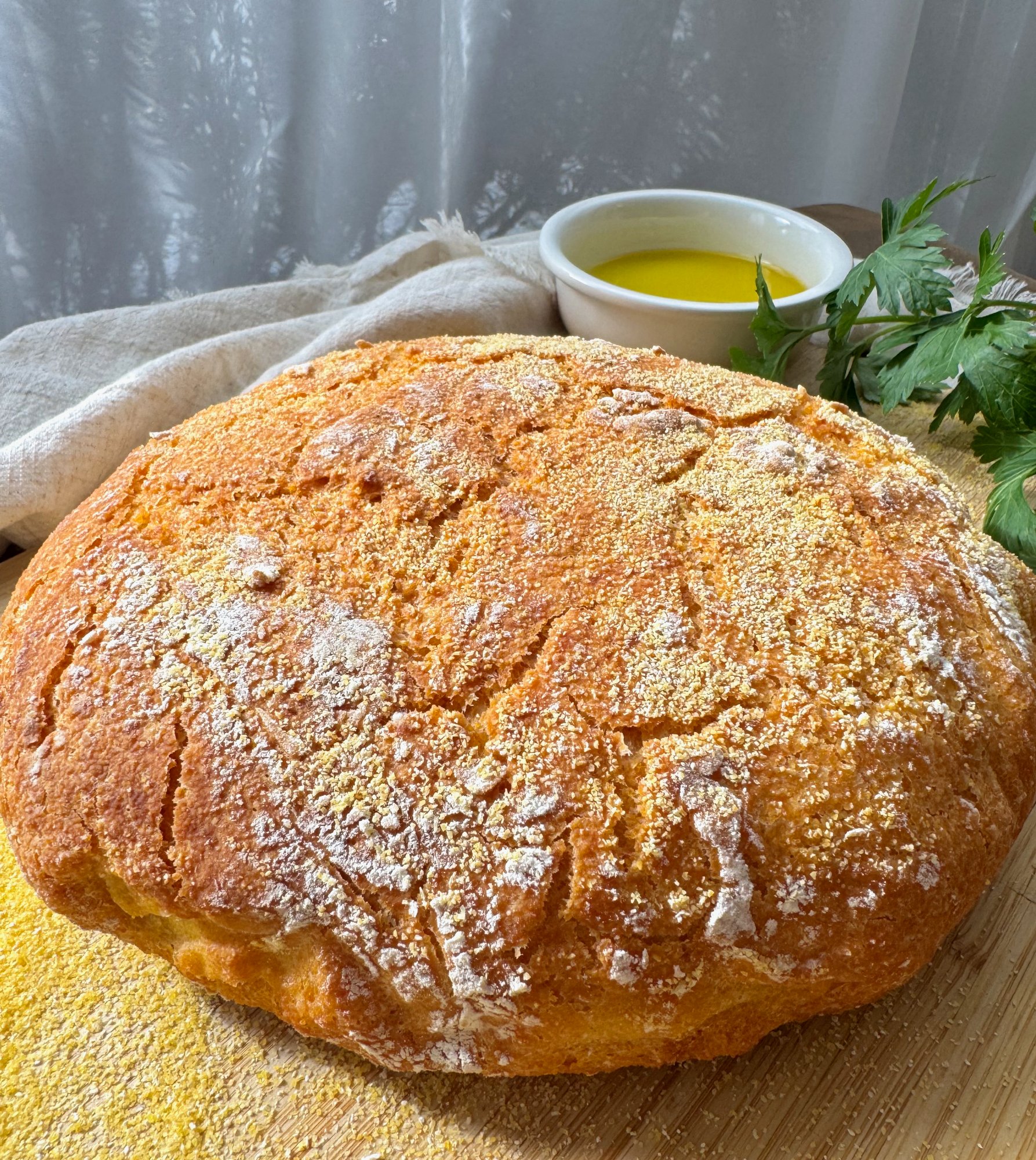 A round loaf of Portuguese corn bread, broa de milho, with a crisp golden crust.