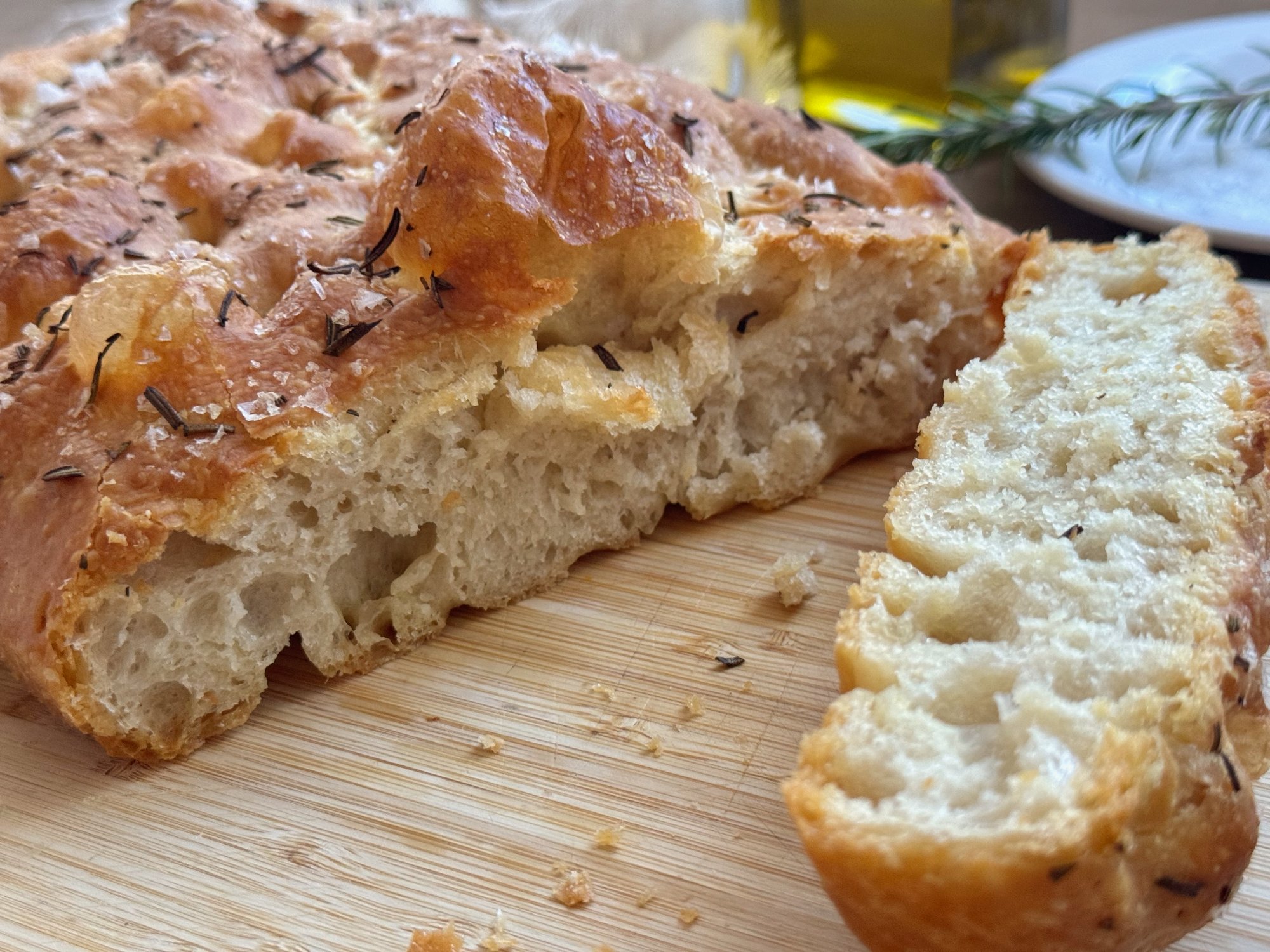 Golden rosemary focaccia with dimpled top, olive oil and flaky salt.
