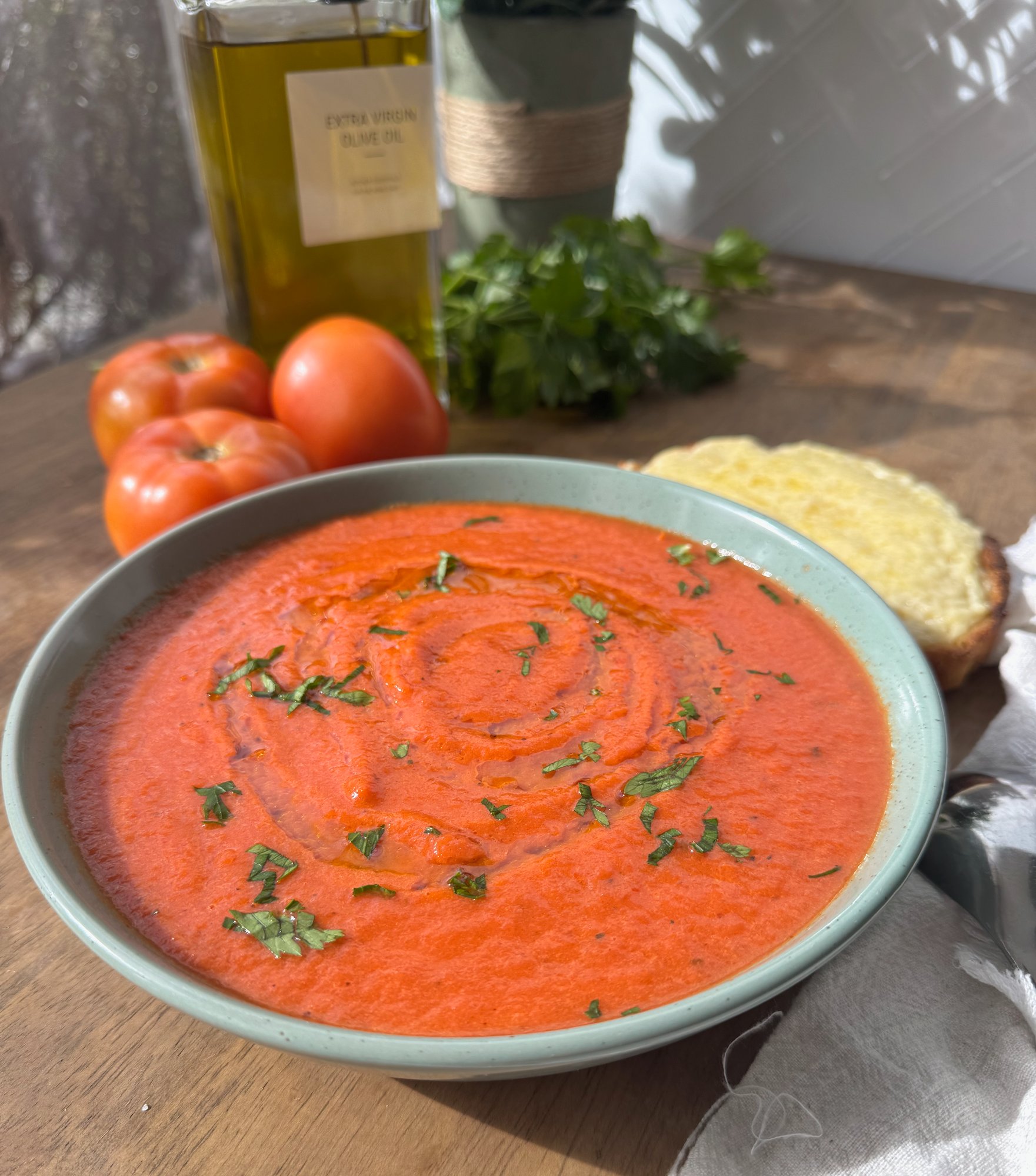A bowl of smooth, deep red roasted tomato and capsicum soup.