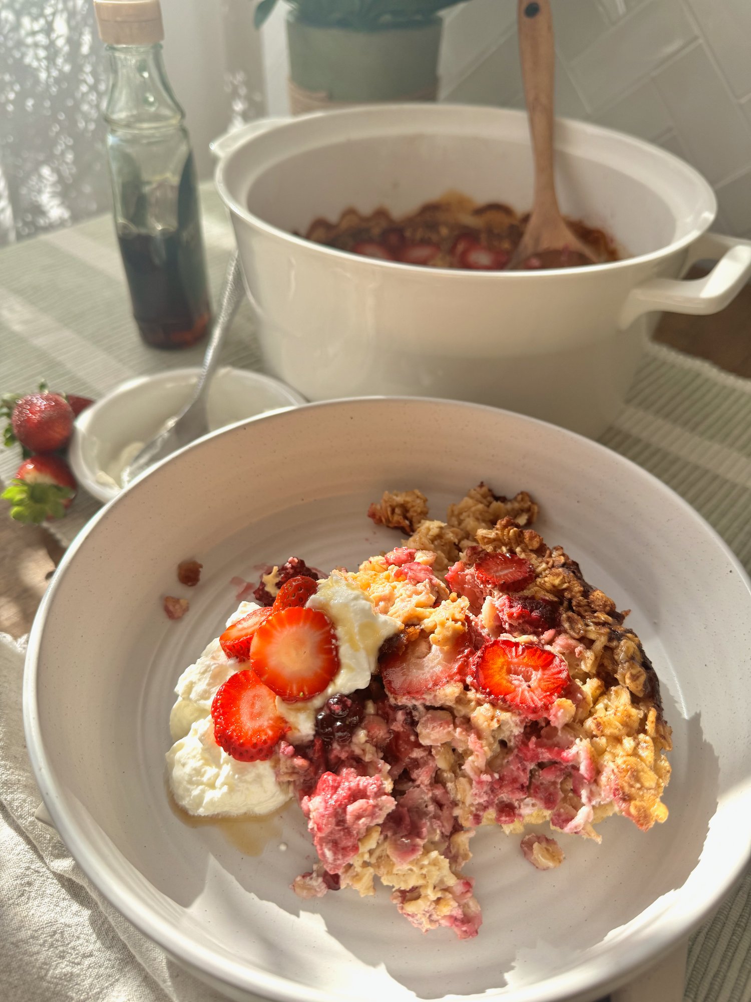 Baked oats with mixed berries, golden at the edges, served with Greek yoghurt.