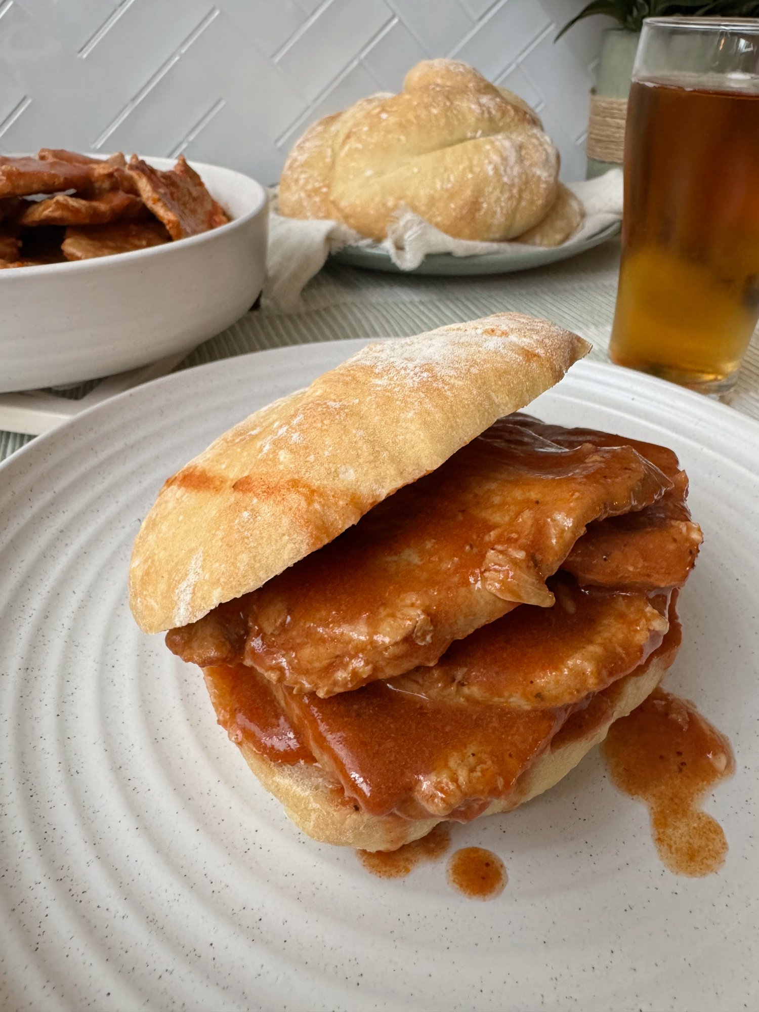 Bifanas à moda do Porto, thin slices of pork in a rich sauce tucked into papo secos rolls.