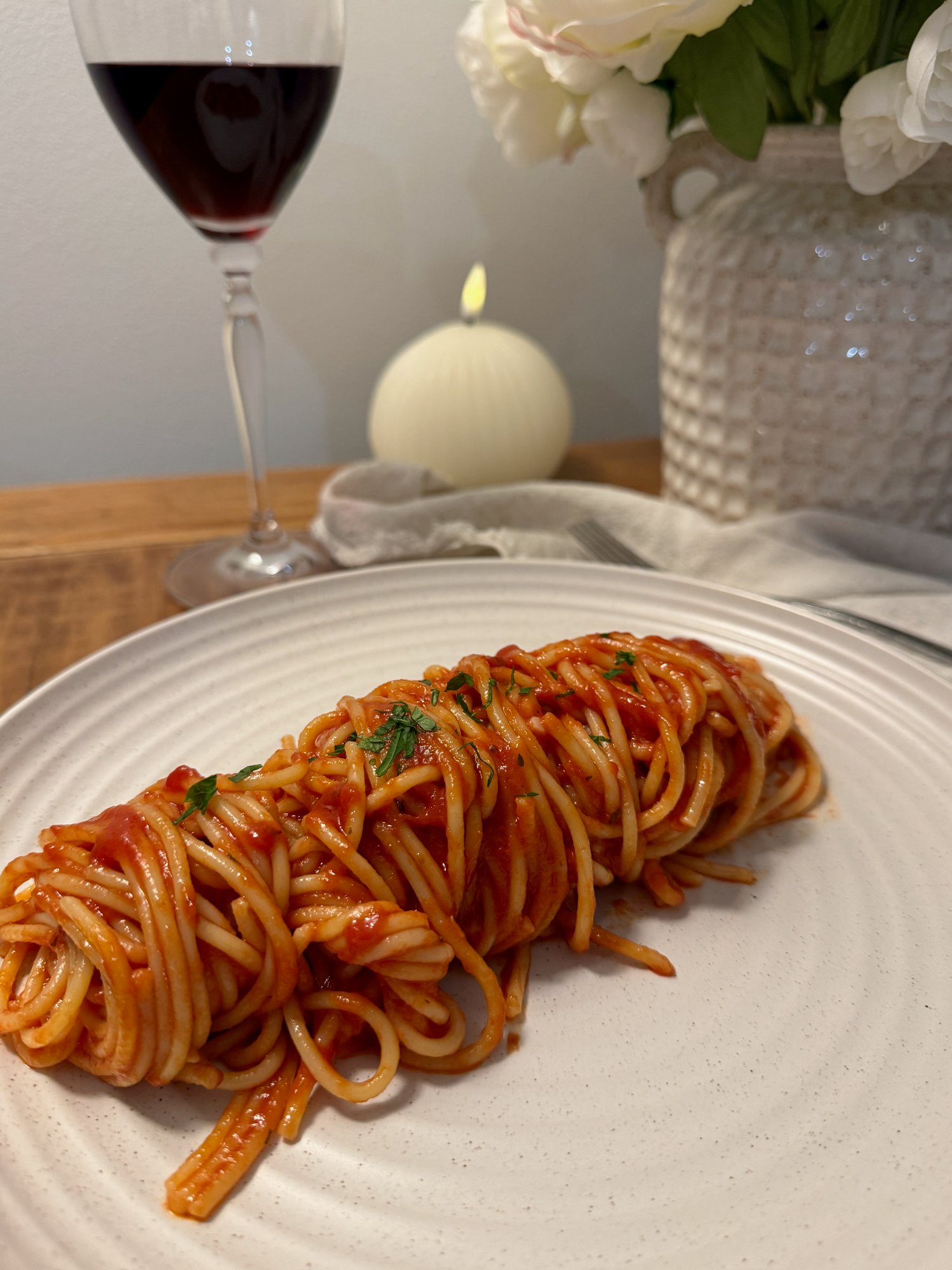 Spaghetti in a simple tomato sauce with fresh basil leaves.