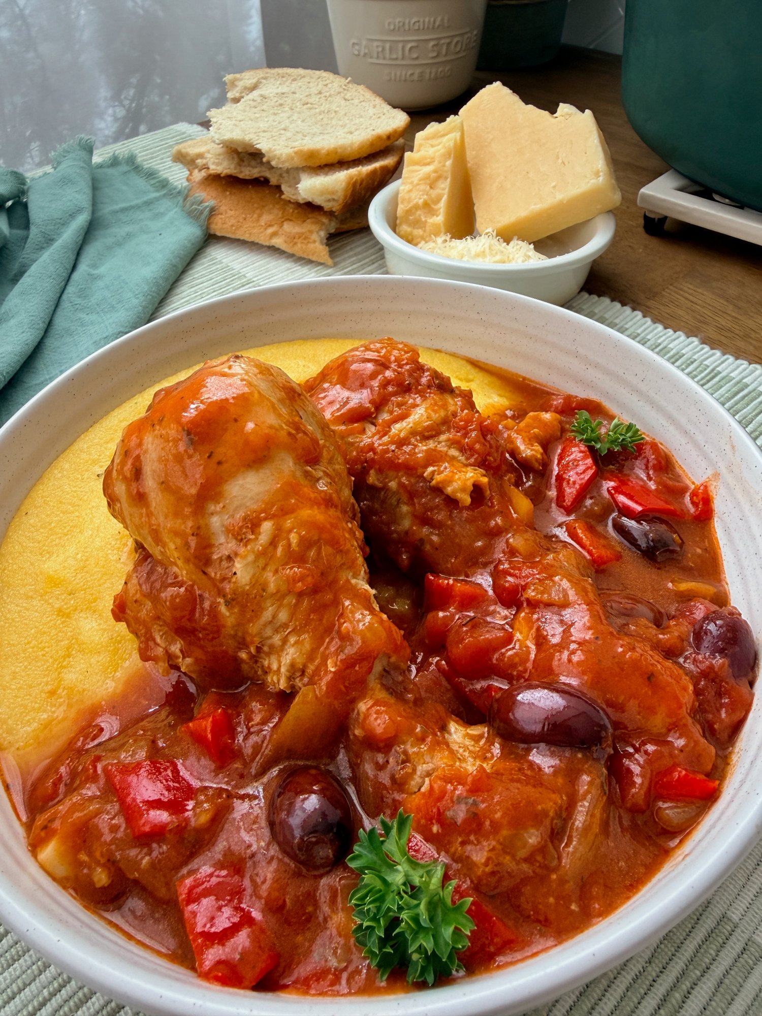 Chicken cacciatore with red capsicum and Kalamata olives in tomato sauce over creamy polenta.