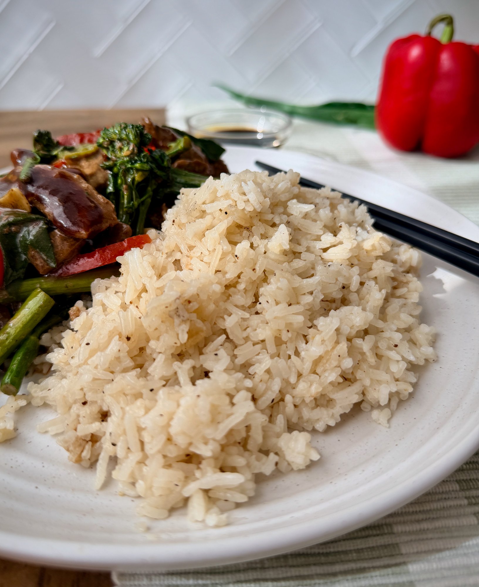 A bowl of jasmine rice flecked with cracked black pepper.