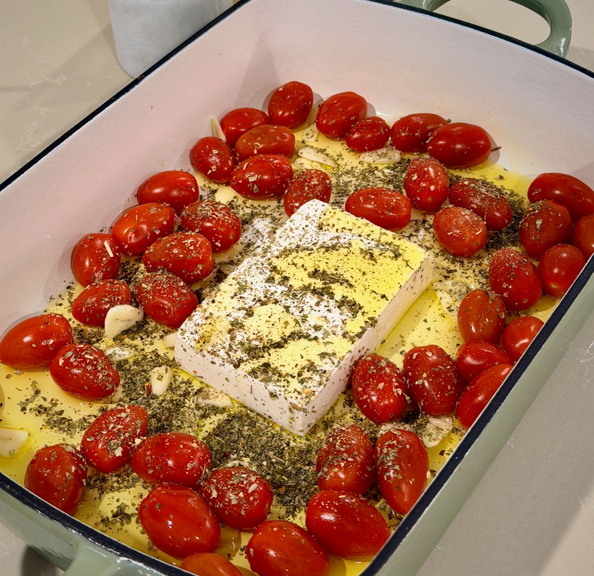 Baked feta gnocchi with roasted cherry tomatoes and spinach in a creamy sauce.