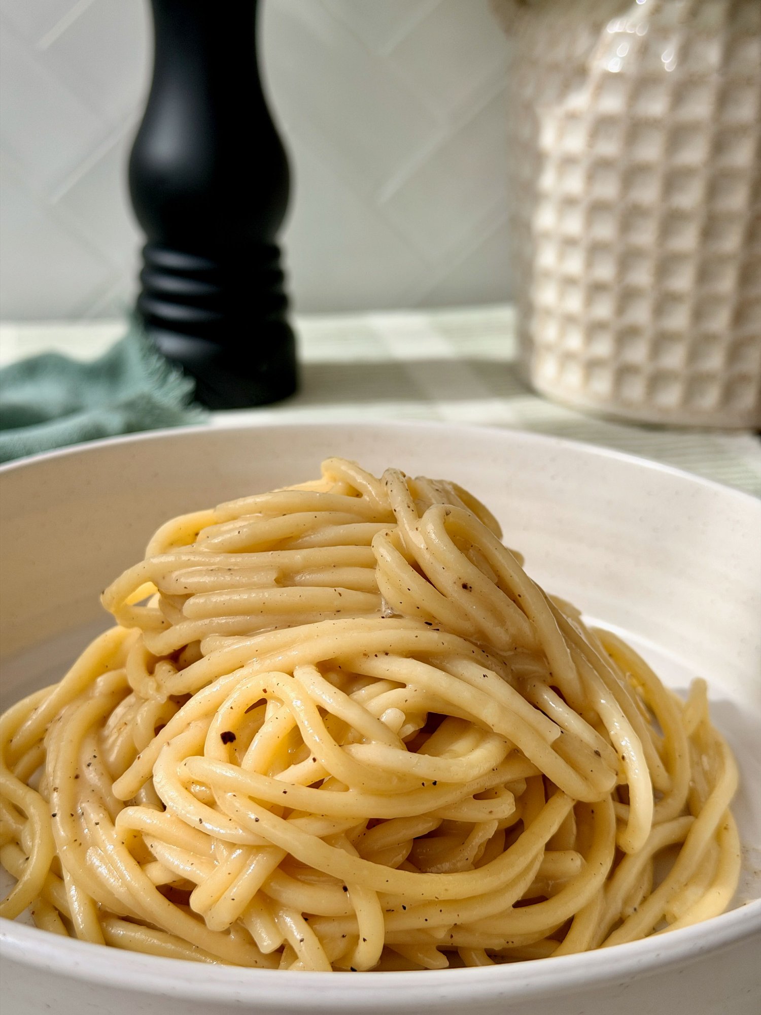 Cacio e pepe, spaghetti in a glossy pecorino sauce with cracked black pepper.
