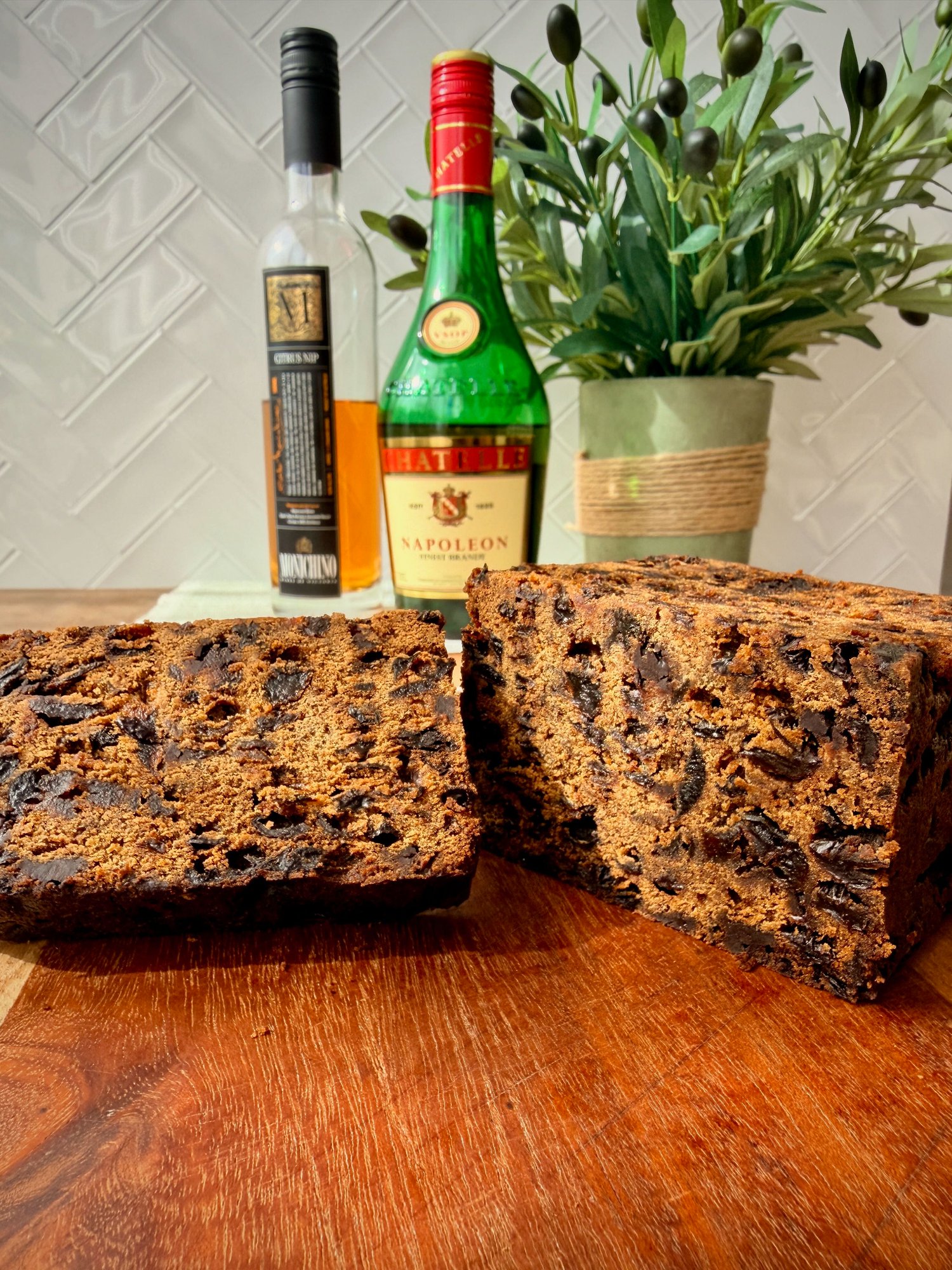 A rich, dark Christmas fruit cake, sliced to show the dense fruit-filled crumb.