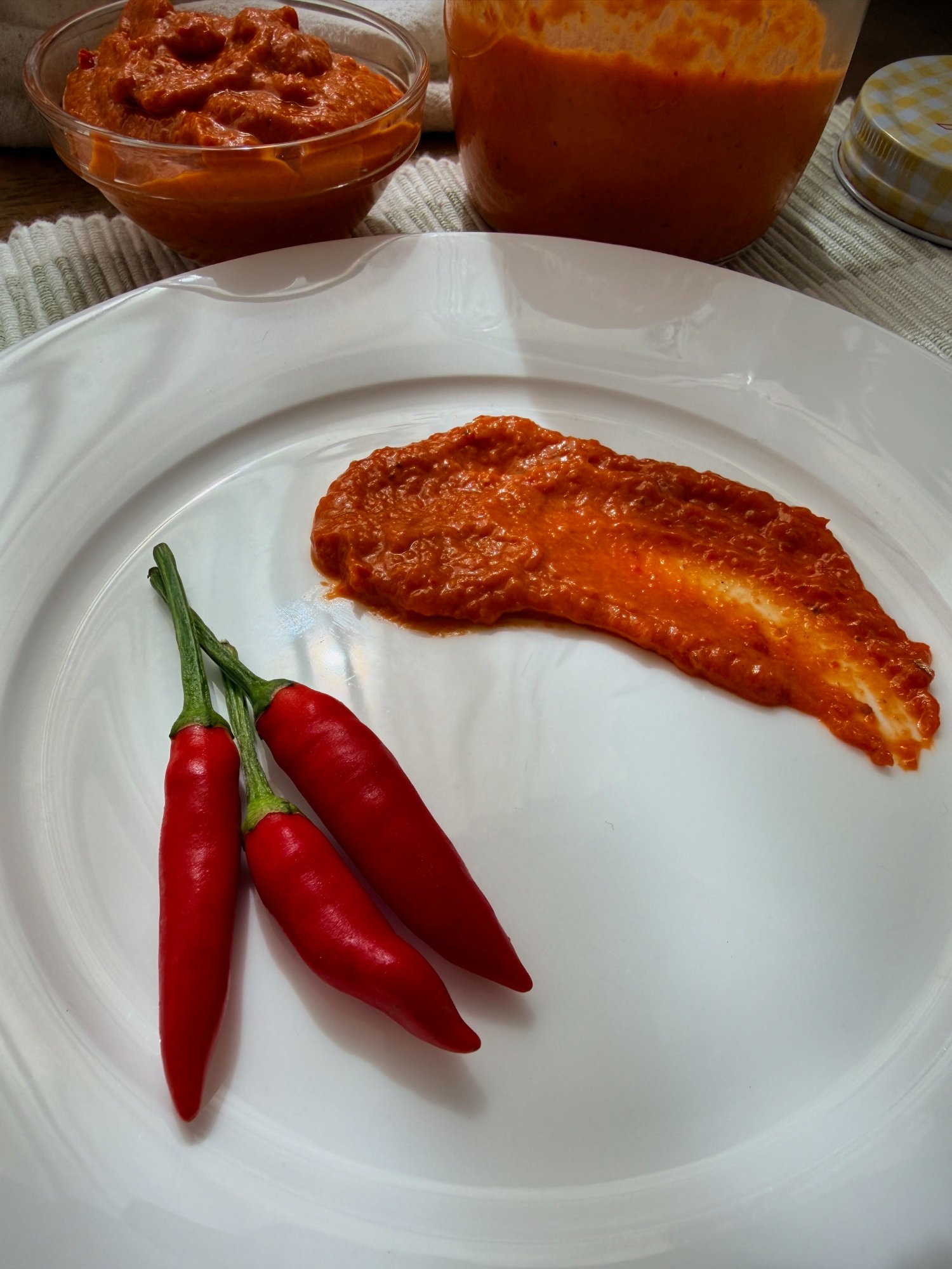 A jar of thick, deep red Portuguese peri peri sauce.