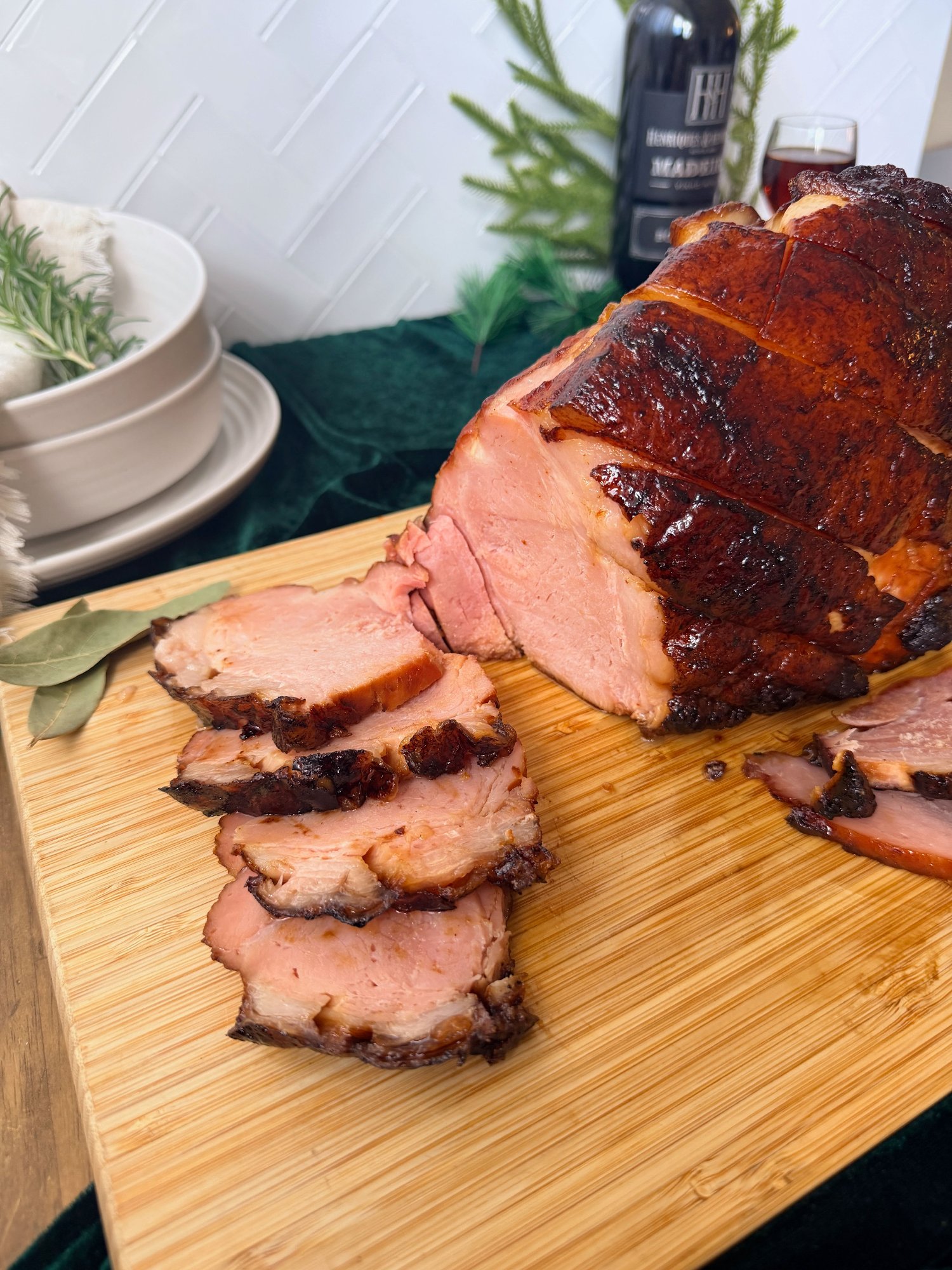 Portuguese Christmas ham with Madeira glaze on a wooden board, sliced to show moist pink meat under a dark caramelised crust