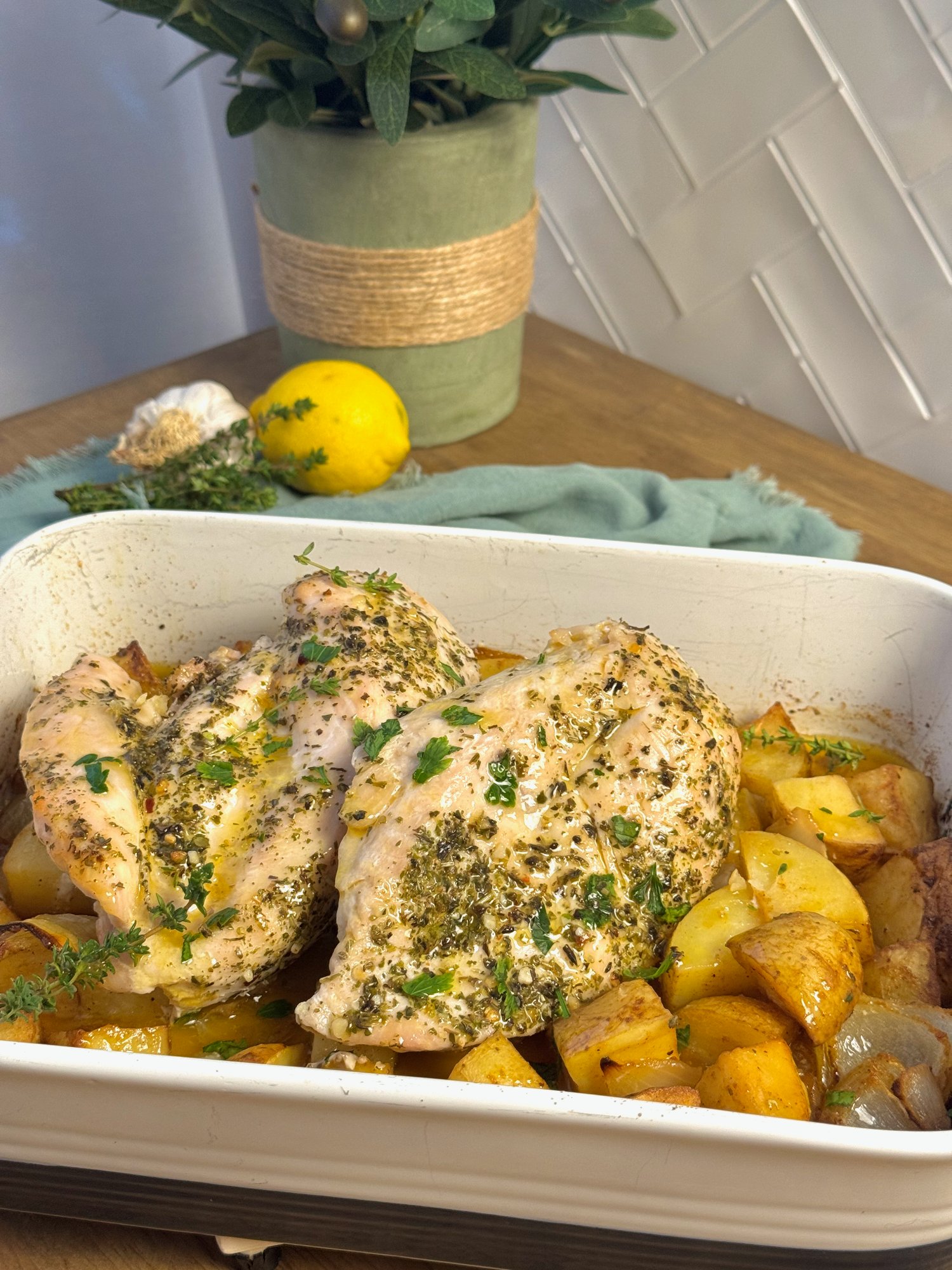 A tray bake of dry brined chicken breasts with golden potatoes, onion, garlic and lemon.