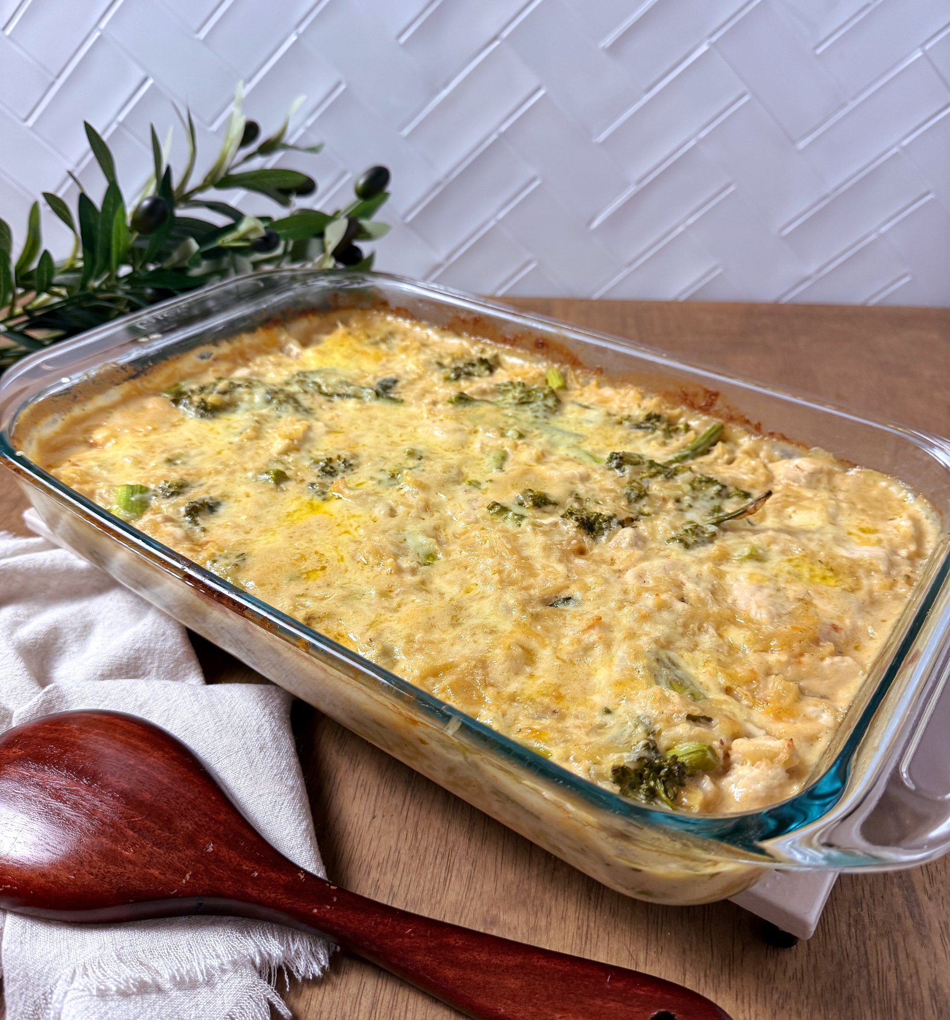 A baking dish of creamy chicken and broccolini risoni bake, golden on top.