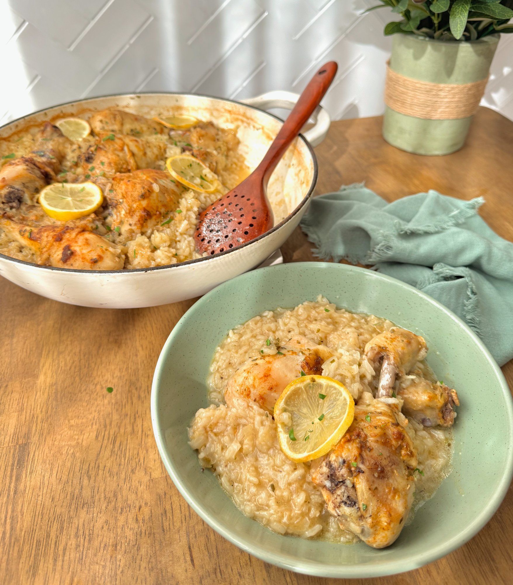 Golden chicken drumsticks baked over lemon garlic rice in one pan with lemon slices.