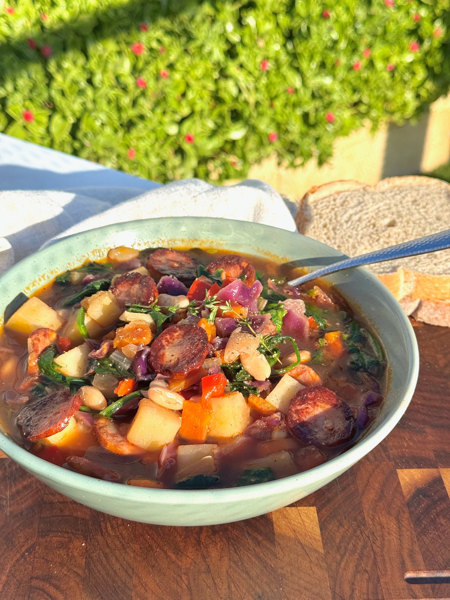 Rustic Portuguese bean soup with chorizo, potato, purple cabbage and spinach in a paprika broth.