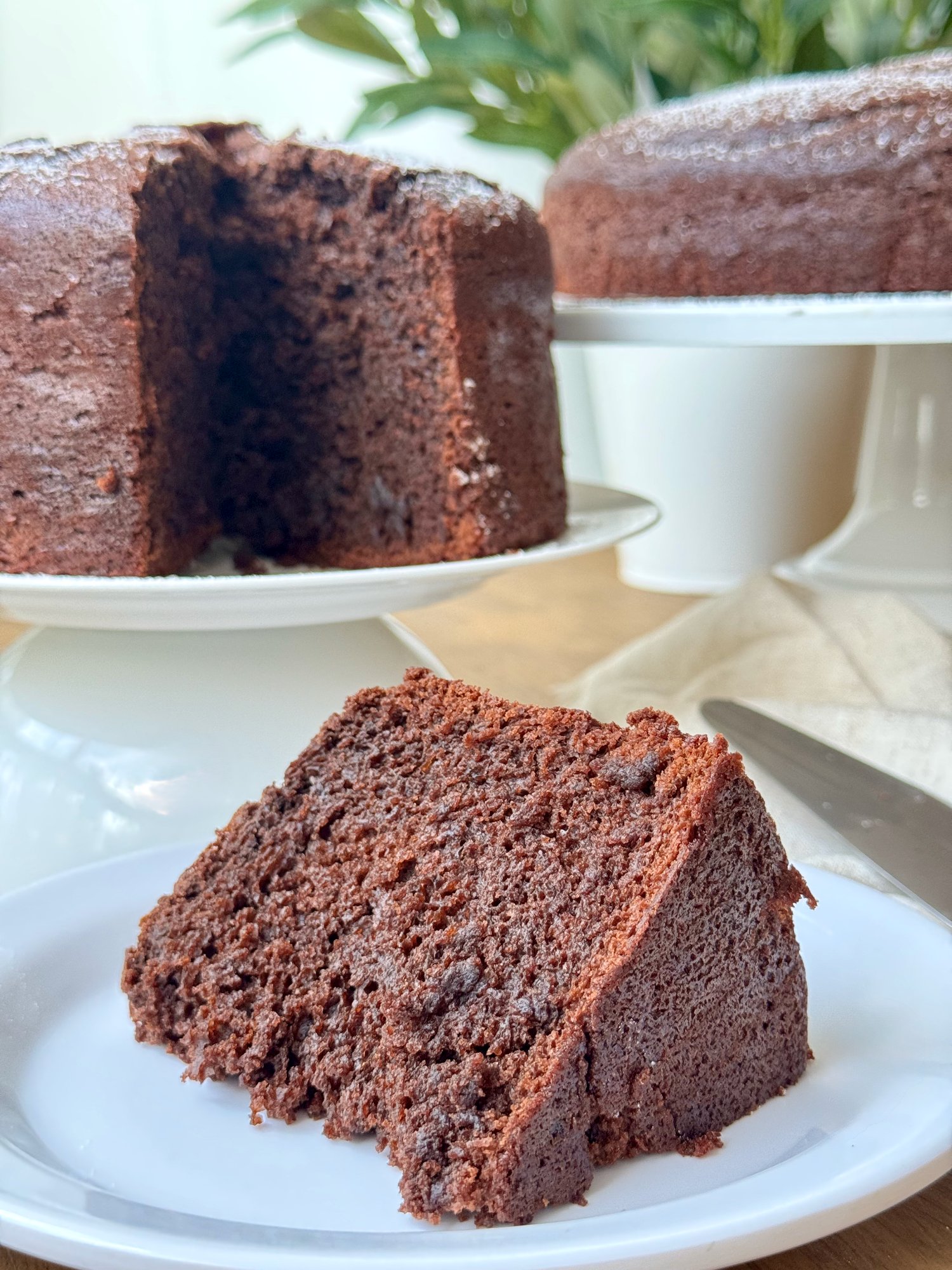 A slice of soft one bowl chocolate cake showing its tender crumb.