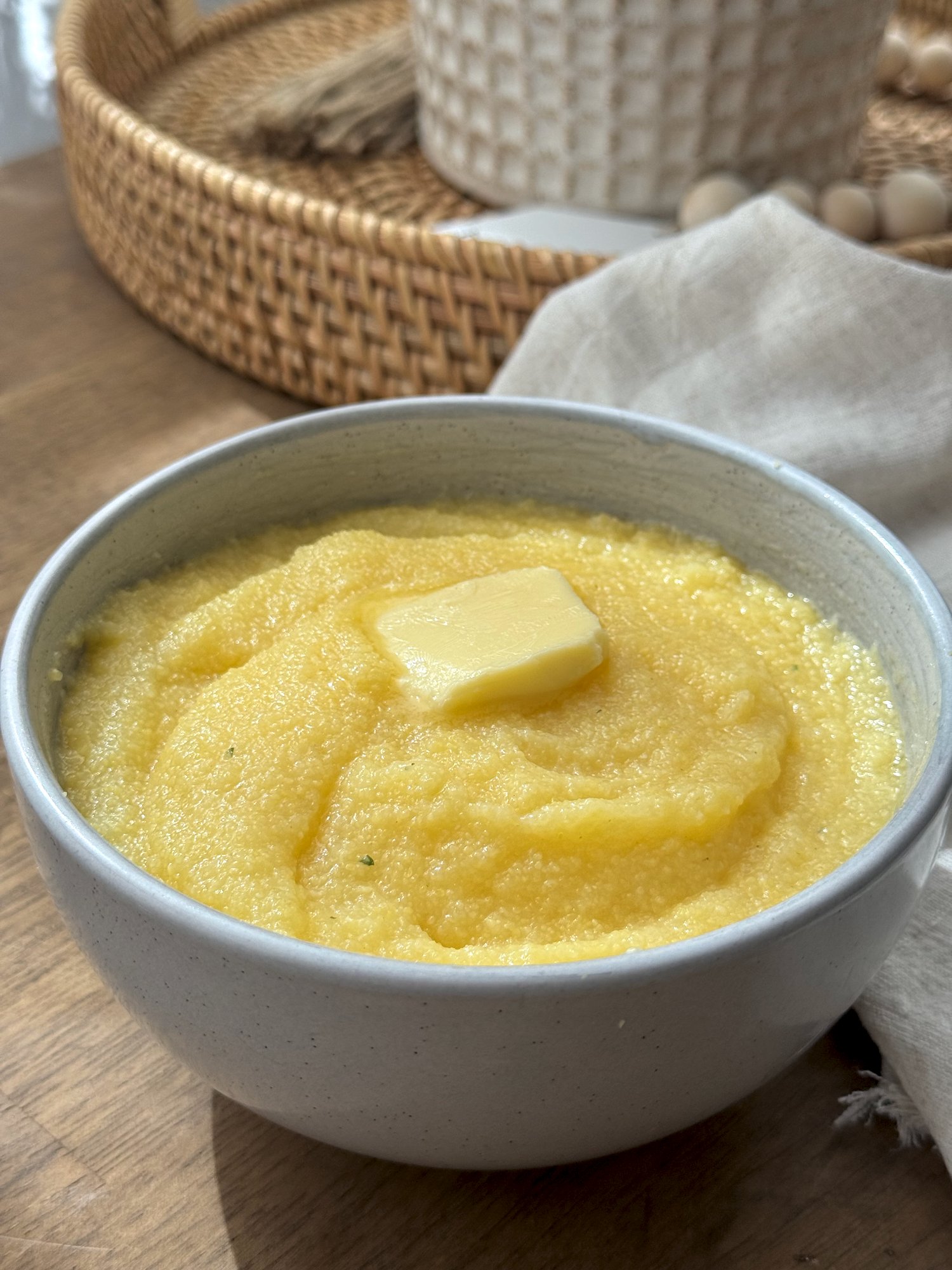 A bowl of soft, spoonable creamy polenta finished with butter.